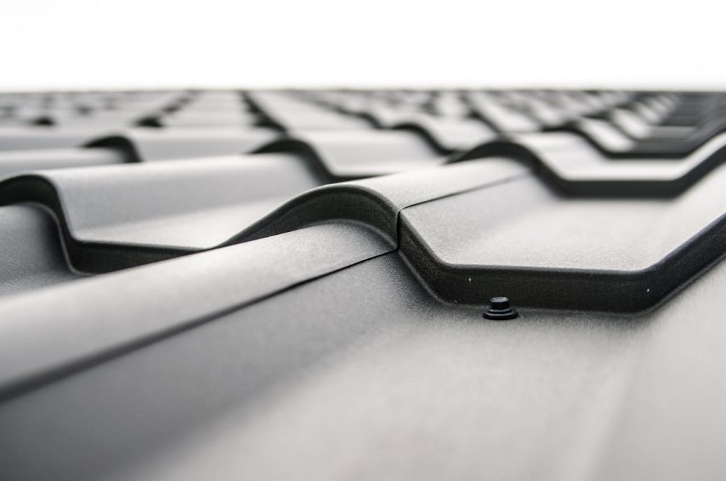 gray-iron-sheet-48882 Close-up view of a metal roofs wavy design showcasing rivets and structural detail.